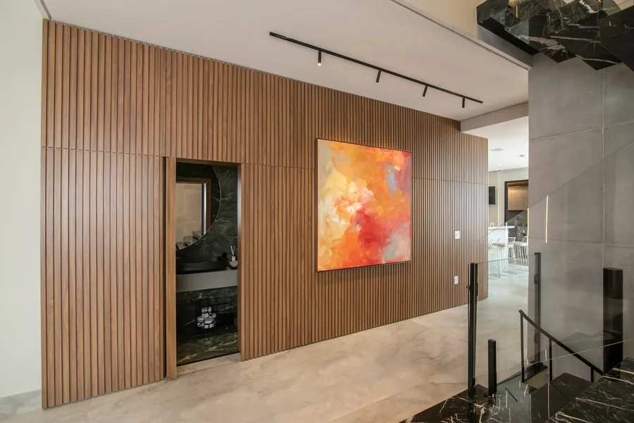 Painel ripado com porta pivotante oculta: continuidade visual na parede e um acesso discreto e sofisticado | Progetto Mobiliamo